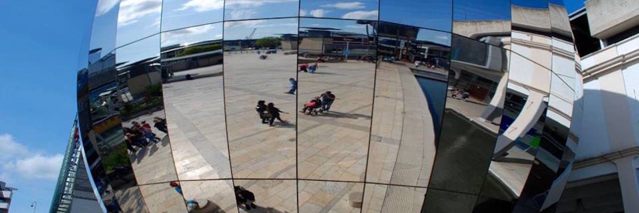 What to Know If You're Embarrassed to Use a Mobility Aid reflection of a shopping center in a mirror
