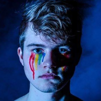 Man with rainbow makeup tears.
