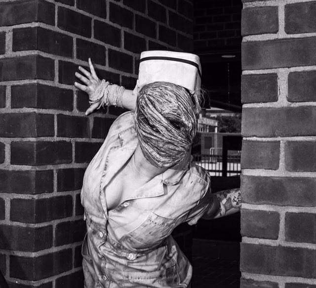 woman doing cosplay as silent hill nurse. her arms are hyperextending due to ehlers-danlos syndrome