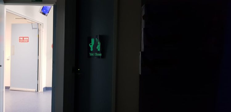 glow in the dark bathroom sign at hospital