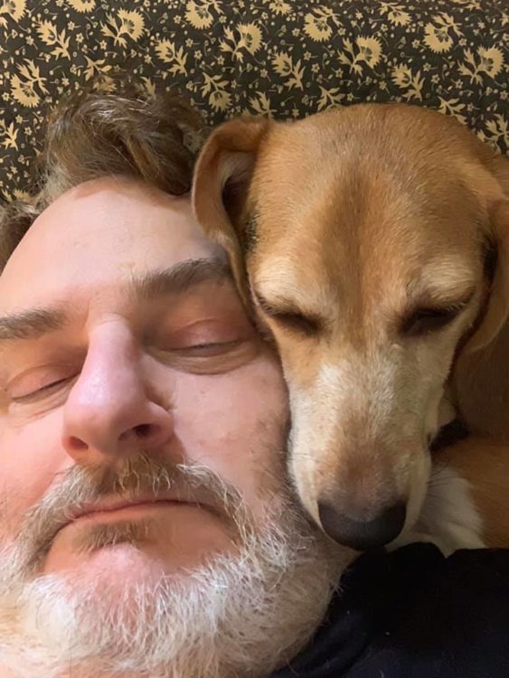 man with dog laying down