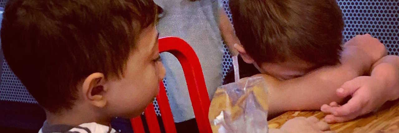 Having to Stand Up for Yourself As Someone With a Disability The author's kids sitting at a table, one with their head down, sad