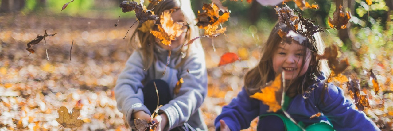 My Daughter With a Disability Made Her First Friend Two girls playing in autumn leaves.