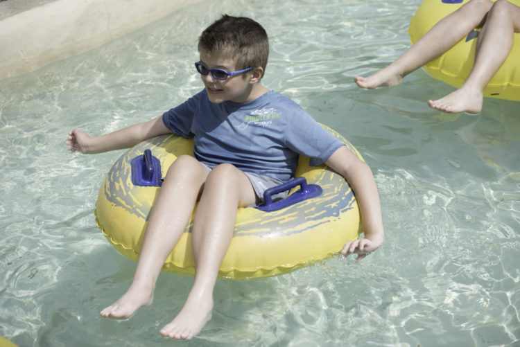 author's son in a floating tube on the water