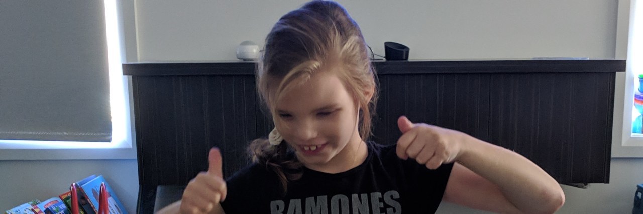 Advice for Someone Whose Baby Was Diagnosed With a Genetic Disorder A little girl is giving a thumbs up while playing.