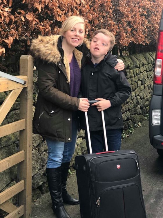 Charlie and Harry Besick holding on to Harry's suitcase as he gets ready to go on his overnight trip.