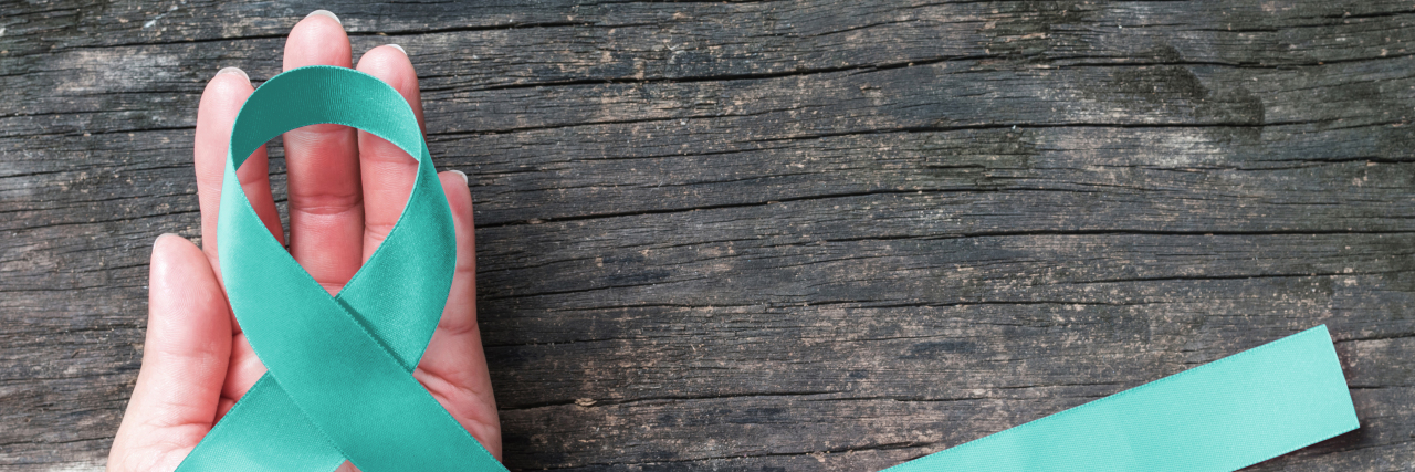 I Don't Fit Tourette Syndrome Stereotypes Teal ribbon awareness on woman's hand for Tourette Syndrome.