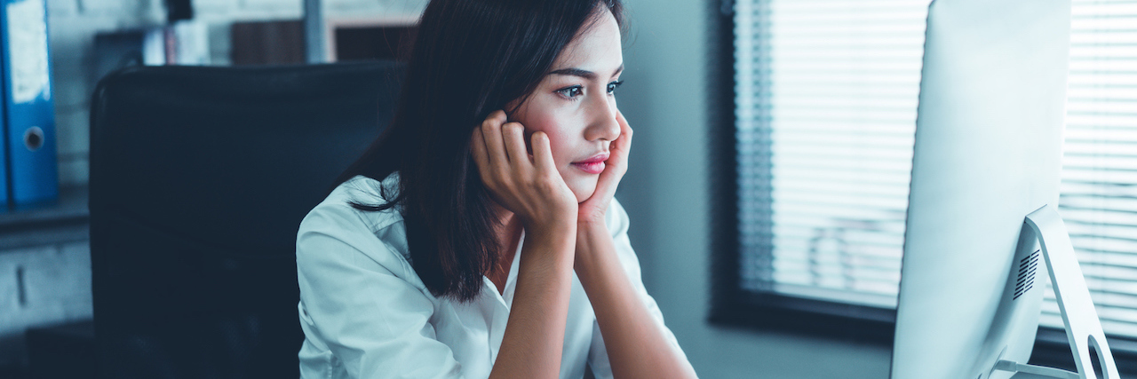 Crying at Work Because of a Celebrity Suicide A woman staring at her computer in an office