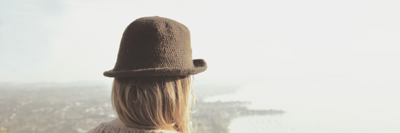 Listening to Your Body Whether You Have a Chronic Illness Or Not Woman takes a breath watching the landscape from a mountain.