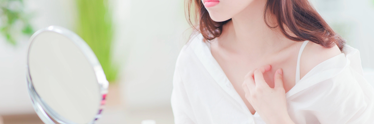 The Side of Eczema People Don't See a young woman is scratching her chest