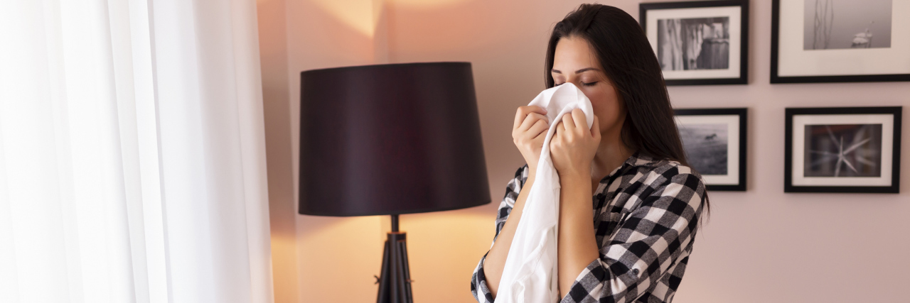 Study Finds It May Be Possible to Smell Parkinson's Disease woman standing next to an ironing board, smelling shirt