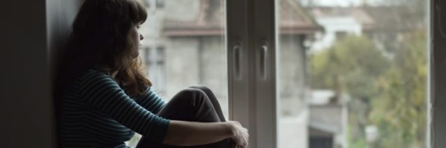 sad woman sitting at the window