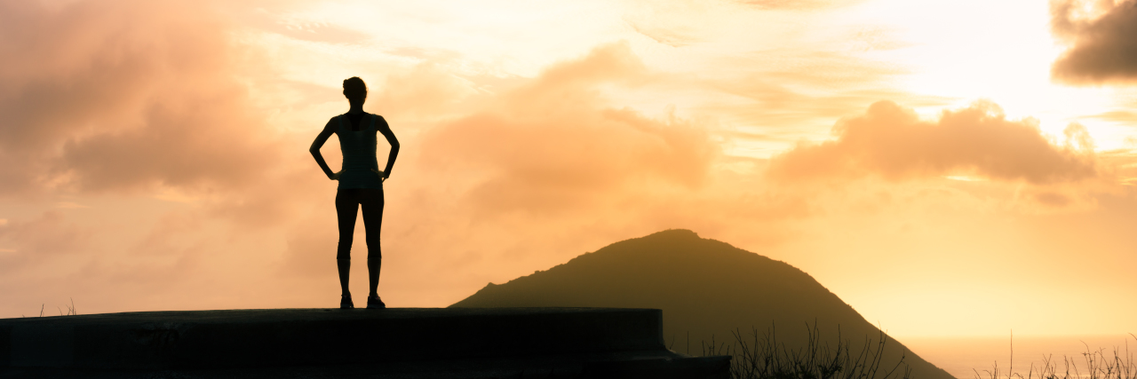 I Am More Than My Mental Illness Woman enjoying beautiful sunset from the mountain top.
