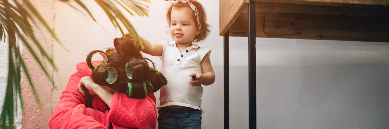Ways to Cope With Postpartum Anxiety a young woman sitting on the floor with her child playing with her hair