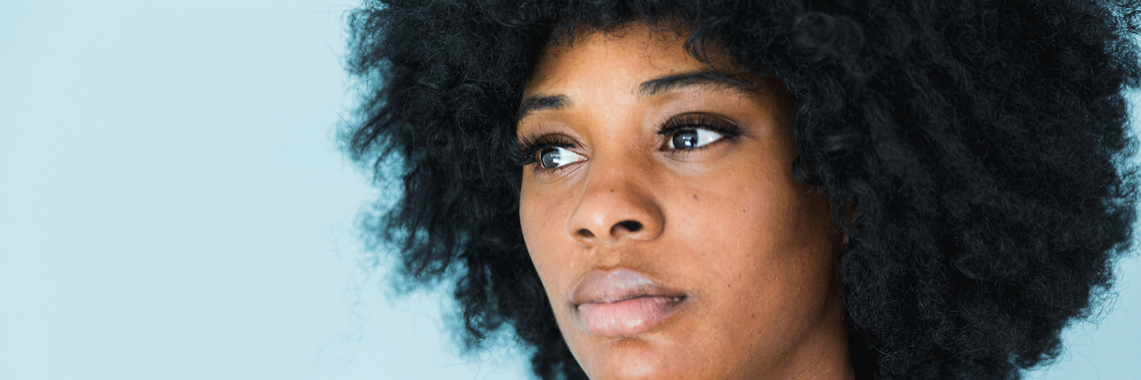 11 Things People With BPD Do That Mean 'I'm Splitting' Black woman with Borderline Personality Disorder looking introspective.