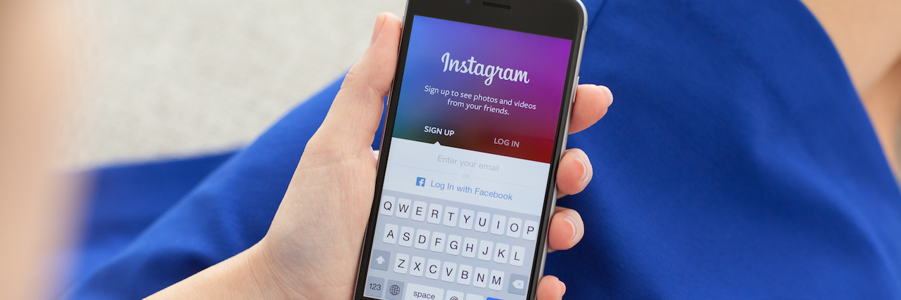 Instagram Limits Use of #Schizophrenic Hashtag Woman holding iphone with Instagram pulled up on it