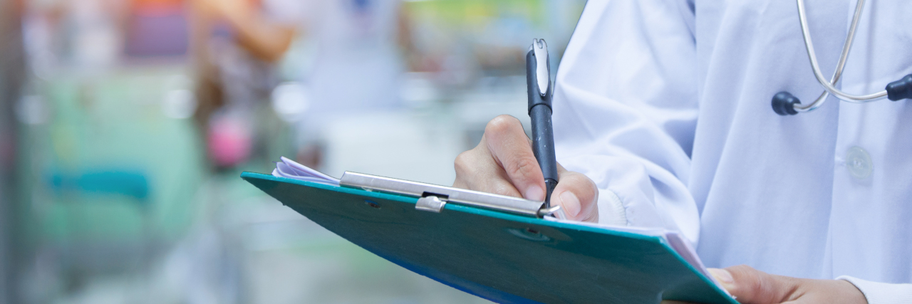 Why Genetic Testing Isn't All You Need When You're Undiagnosed doctor writing on a clipboard in the hospital