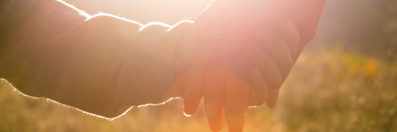 Parenting a Child With Duchenne Muscular Dystrophy: What It's Like mother and child hands abstract sunset shot