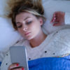 girl laying in bed on her cell phone