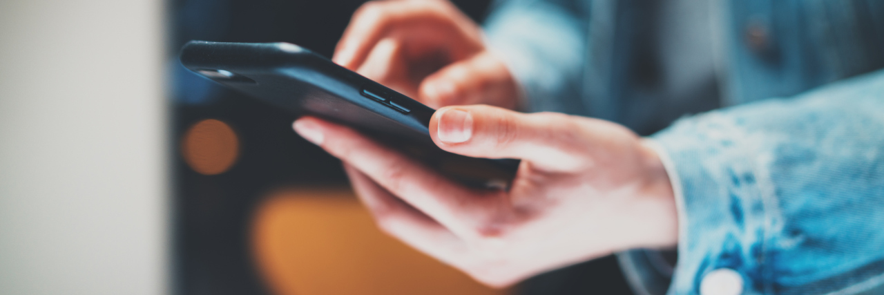 PTSD Apps for Veterans close up photo of woman on smartphone with blurred background