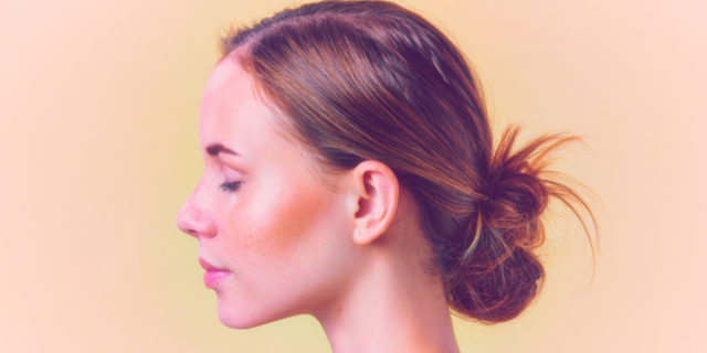 Redhead woman with freckles. Her visible eye is closed.