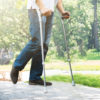 Man Walking With Crutches In Park