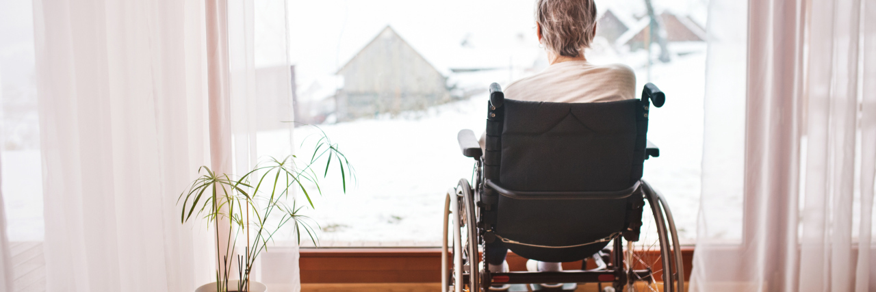 The Abuse of People With Disabilities Needs to Stop photo of woman from behind sitting in wheelchair looking out of window