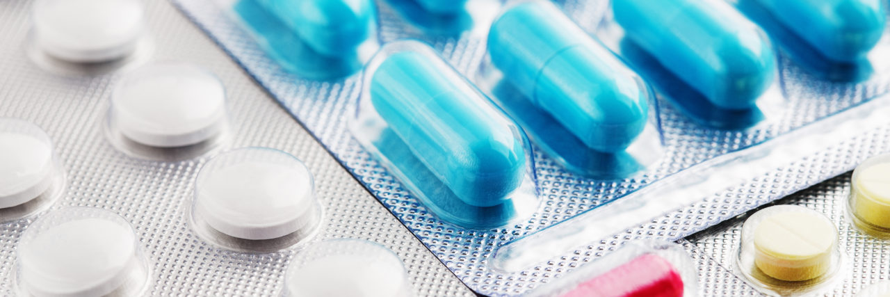 How Pharmacy Benefit Managers Are Harming Patients Pills in white, blue and other colors. Pills in plastic package.