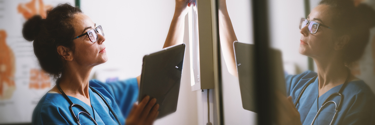 A Former Nurse's Advice for Chronic Illness Patients A nurse looking at a chart on a wall