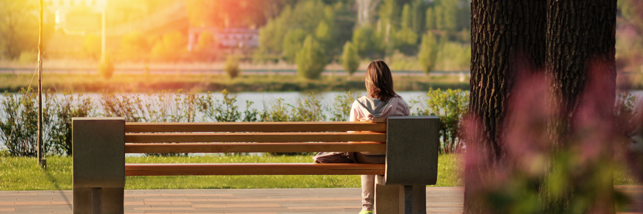 Being Born With a Disability Has Actually Enhanced My Life young woman sitting on bench near a lake