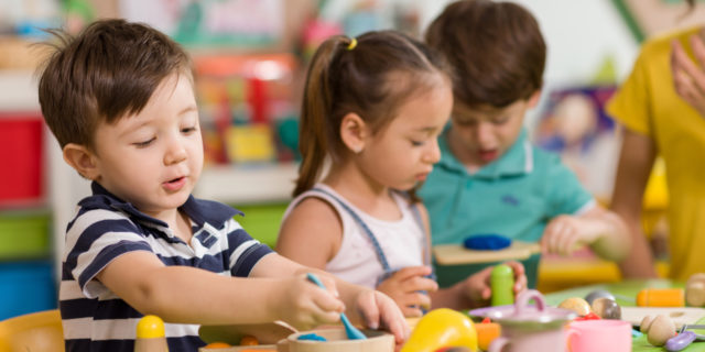 How Early Intervention Services Helped My Son With Autism Children playing with clay in classroom.