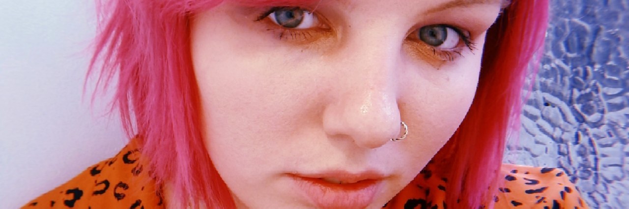 Adjusting to Using a Mobility Aid Jodie with pink hair and an orange shirt.