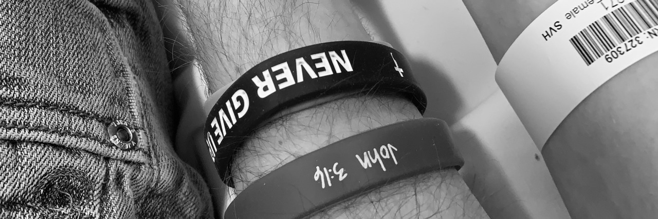 Finding Love When Both Partners Have Disabilities Couple holding hands; he is wearing strength bracelets, while she wears a hospital bracelet..