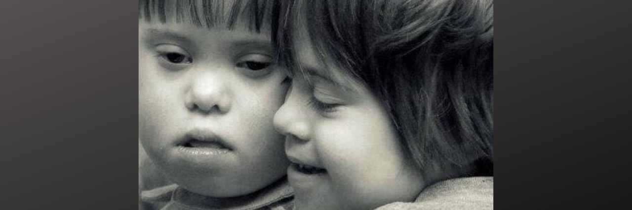 Black and white image of two kids with Down syndrome