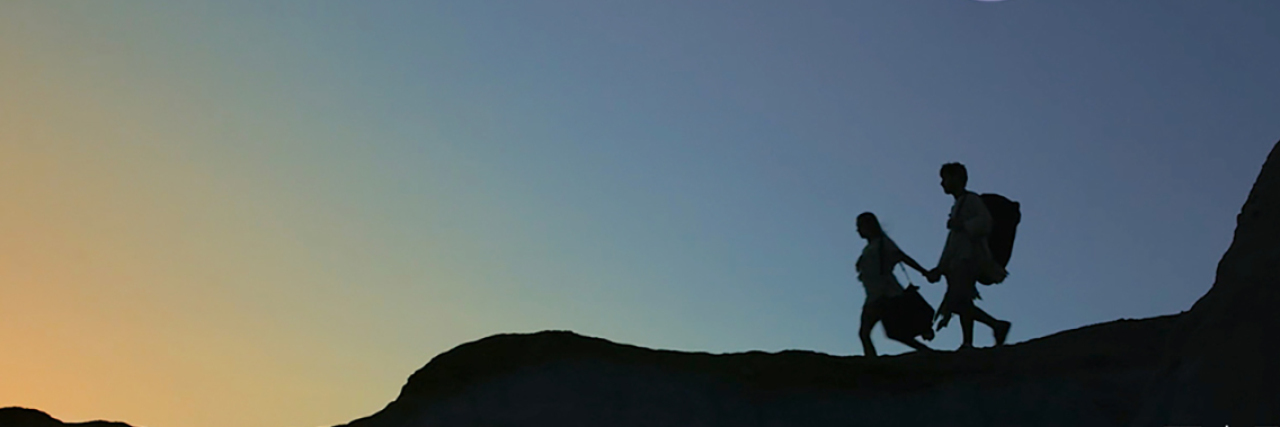 ReelAbilities Film Festival 2019 poster. Silhouette of two people hiking over a mountain.