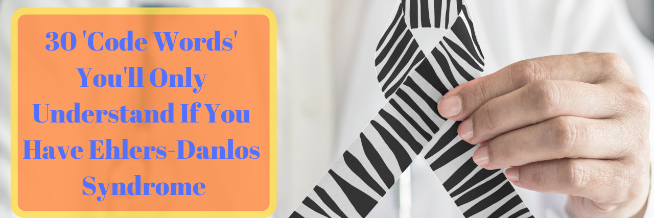 'Code Words' Only People With Ehlers-Danlos Syndrome Understand Man holding a EDS ribbon with words "30 'Code Words' You'll Only Understand If You Have Ehlers-Danlos Syndrome"