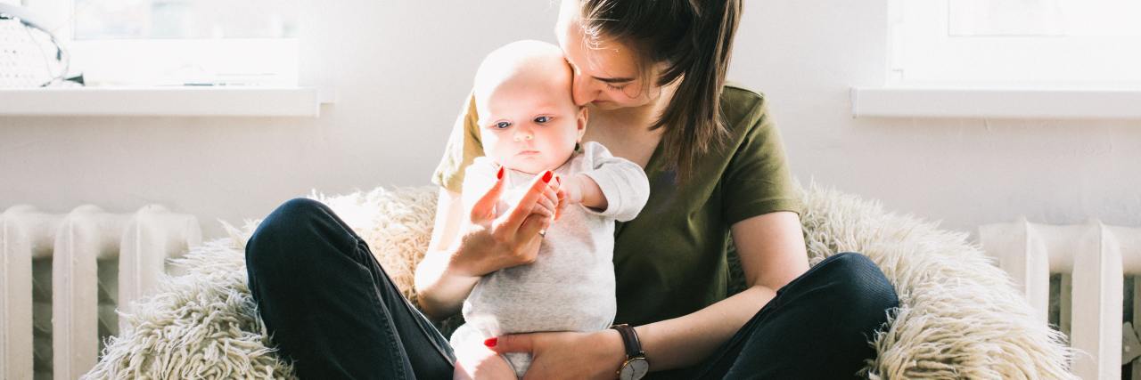 How I Cope With the Unknowns of Motherhood With Diabetes woman sitting on share with baby in her lap