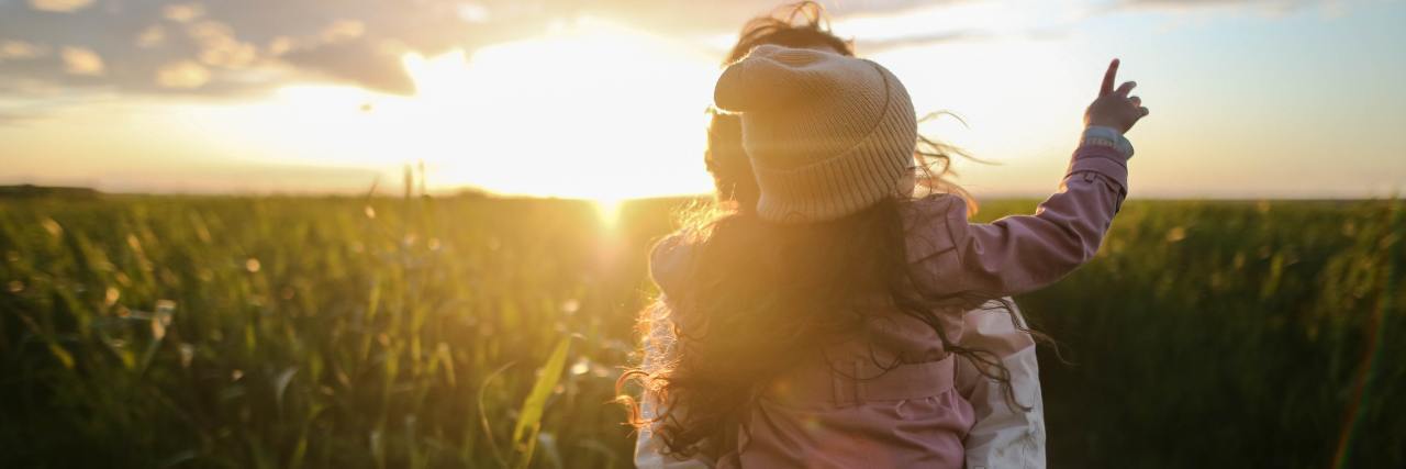 To Moms With Depression Who Are Afraid They Will Be Judged woman holding young daughter in sunset field