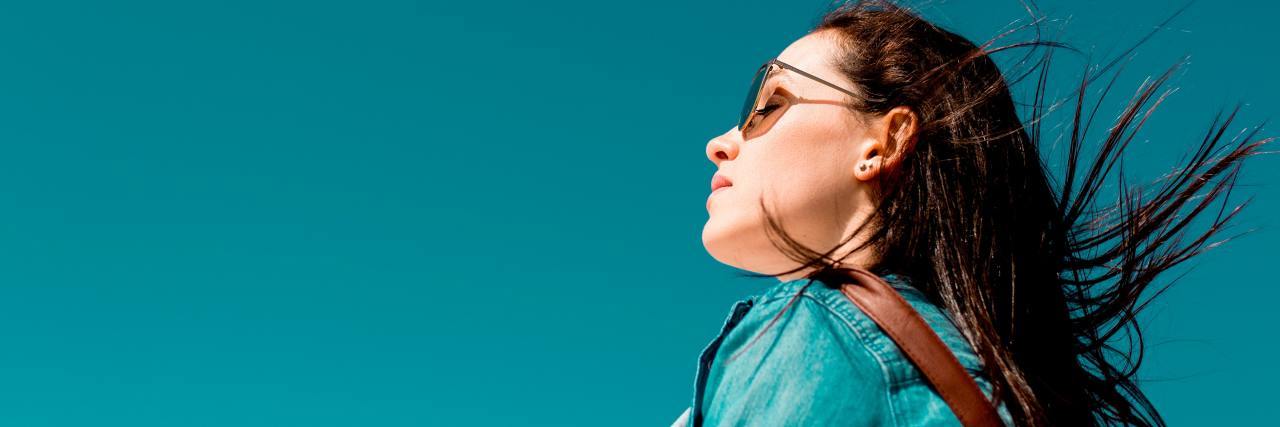 woman wearing sunglasses looking at blue sky