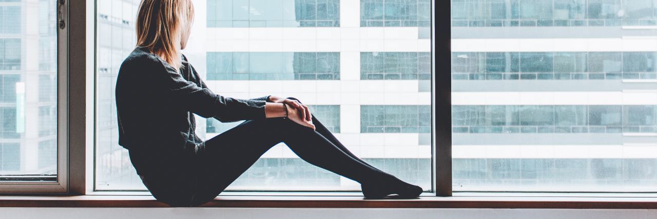 I'm Afraid I'll Never Get Better From Depression and Anxiety photo of young woman sitting on window still looking out of large windows with wistful look