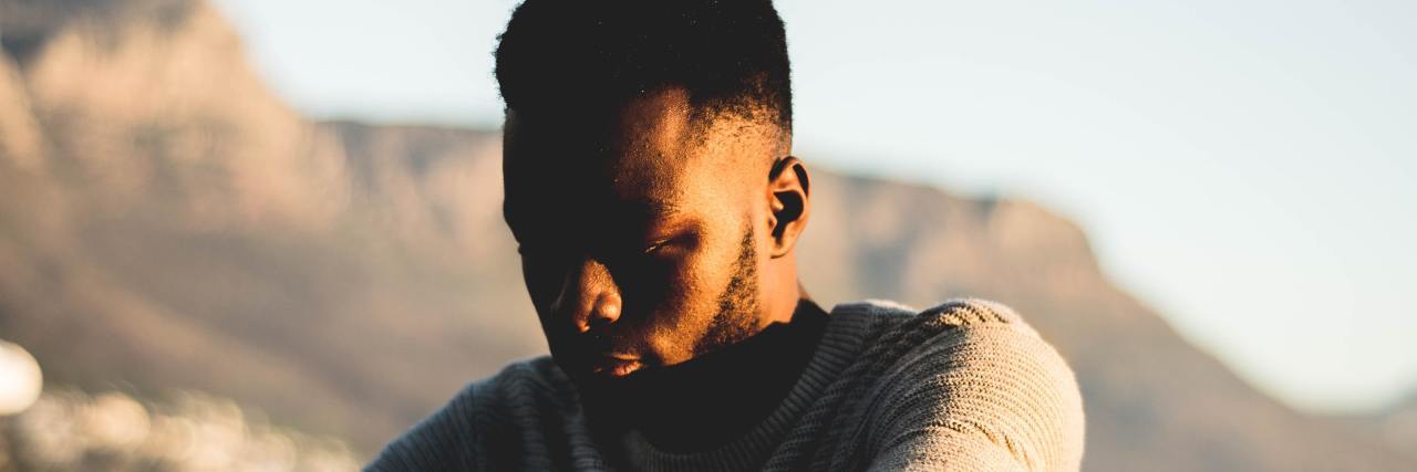 Feeling Alone Is a Chance to Find Yourself man sitting outside near beach head down