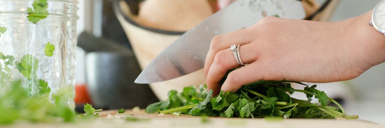 The Challenges of Needing a Special Diet Due to Health Conditions woman chopping herbs on a cutting board
