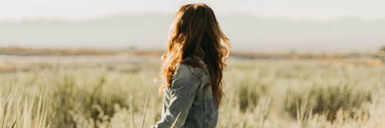 I'm Scared My Chronic Illness Won't Be Taken Seriously at Home photo of young woman in field looking into distance