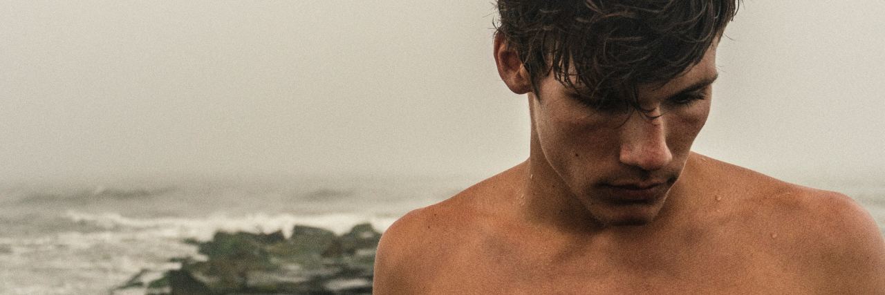 Facts You Need to Know About My Life With BPD photo of man without shirt standing on misty rocky beach looking away from camera