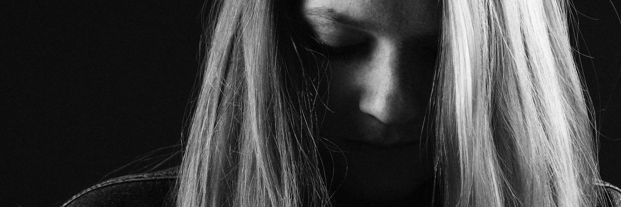 Why Is NEDA Week Hard Even Though I'm in Eating Disorder Recovery? black and white photo of young blonde woman with face in shadow