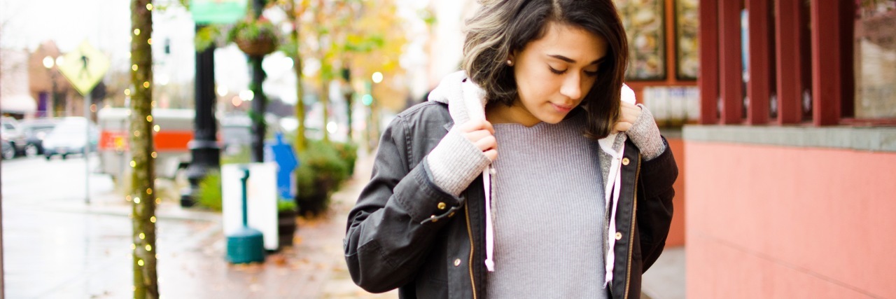 What You Might Not Know About Chronic Pain photo of young woman on street wearing large coat