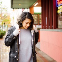 photo of young woman on street wearing large coat