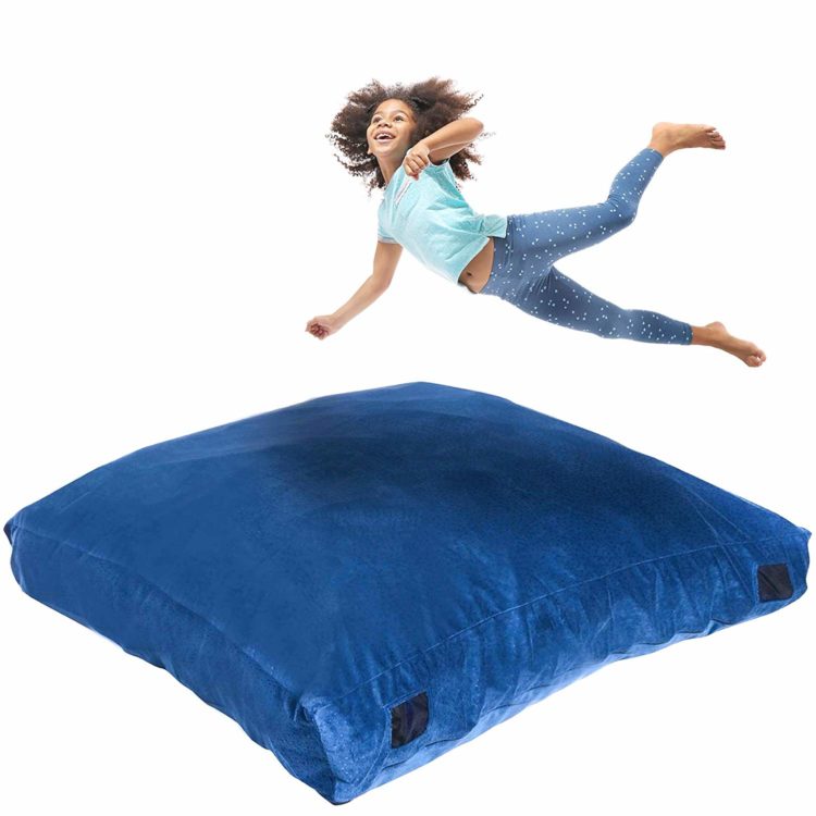 Blue crash pad and child jumping to land on it