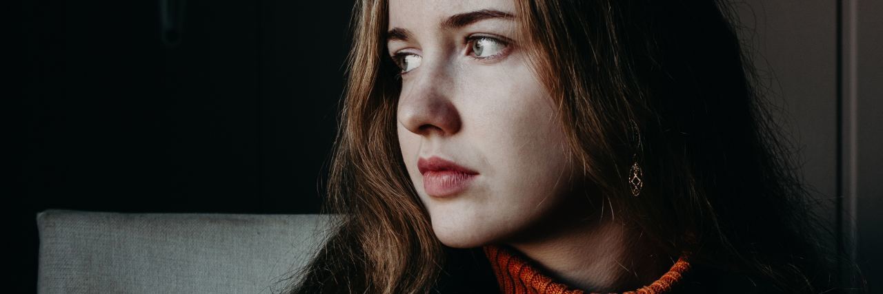 Colleges Need Better Mental Health Care and Suicide Response photo of young woman in coffee shop looking serious and concerned