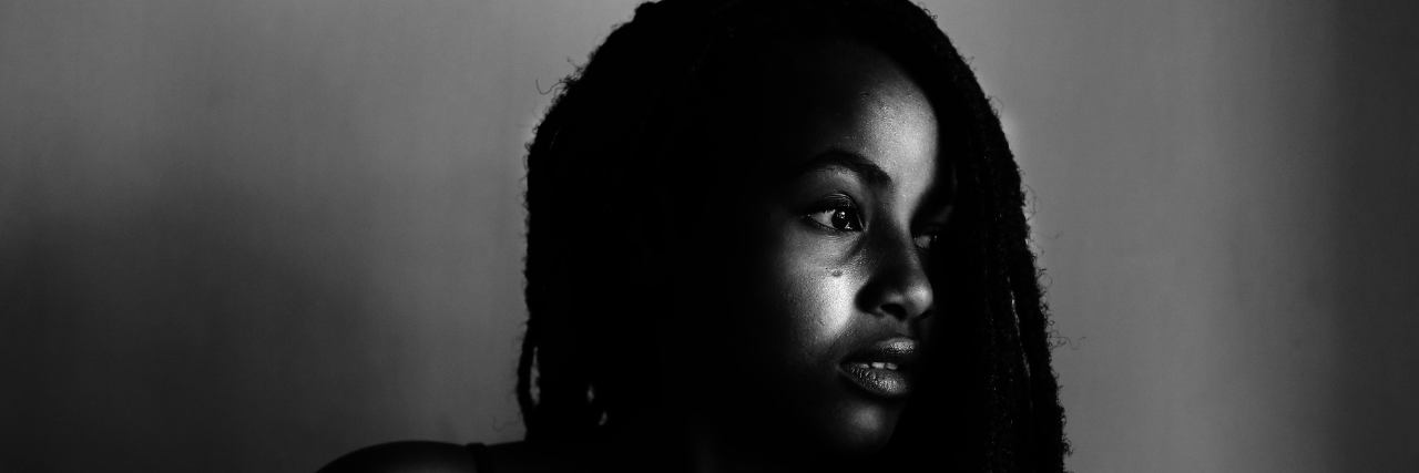 11 'Habits' of People Living With Complex PTSD A black and white photograph of a woman, staring to the side with only half her face visible. 11 Habits of People Living With Complex PTSD